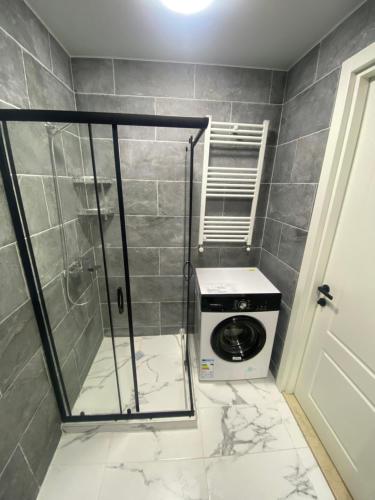a washing machine in a bathroom with a shower at Cozy apartment Dvali in Bakuriani