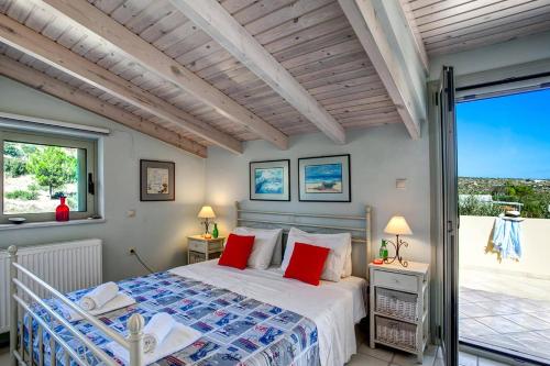 a bedroom with a bed with red pillows at Villa Olive Grove by Villa Plus in Marathi