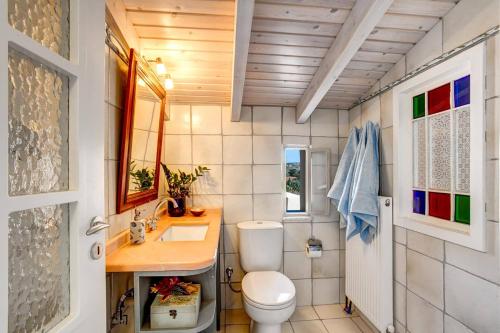 a small bathroom with a toilet and a sink at Villa Olive Grove by Villa Plus in Marathi