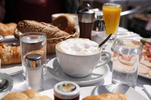 a table topped with a cup of coffee and bread at Hotel zur Heideblüte in Hambühren