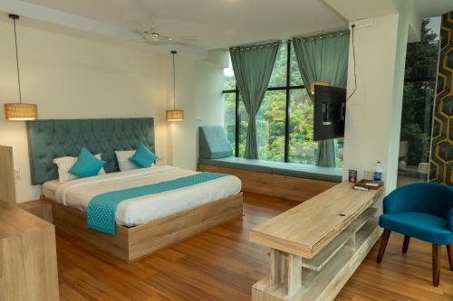 a bedroom with a bed and a blue chair at Joven's central hotel in Bangalore