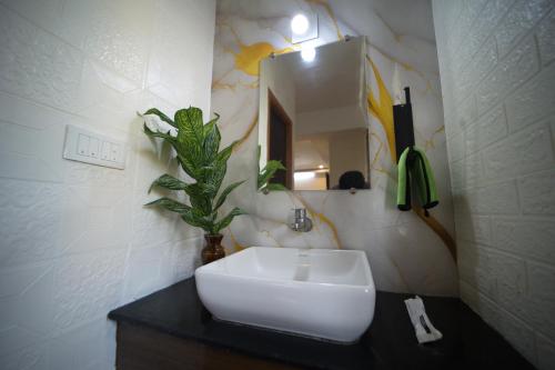 a bathroom with a white sink and a mirror at Sri Saai Surguru Residency in Pondicherry
