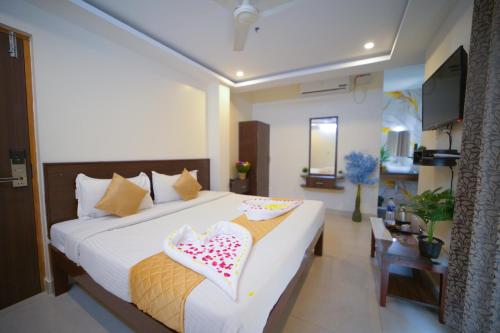 a bedroom with a large bed with pillows on it at Sri Saai Surguru Residency in Pondicherry