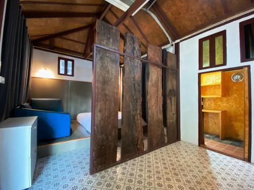 a room with a bed and a wooden door at เรือนเงินตรา in Ban Khlong Hok