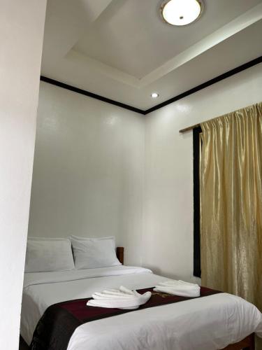 a bedroom with two beds and a window at Janh Ya Phone Guesthouse in Pakbeng