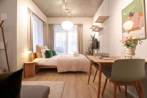 a bedroom with a bed and a table and a dining room at Ken's Place Minami-Azabu in Tokyo