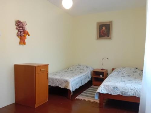 a room with two beds and a dresser in it at House Veli Iz oldtown in Veli Iž