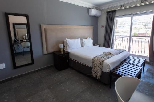 a hotel room with a bed and a balcony at Marilyn Boutique Hotel in Durban