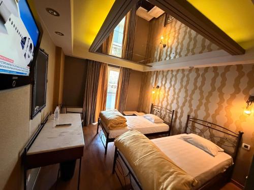 a room with two beds and a flat screen tv at HOTEL PRIVE in Skaramangás