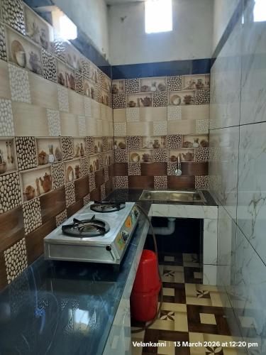 a kitchen with a stove top oven in a room at Hotel Grand Arputha in Velankanni