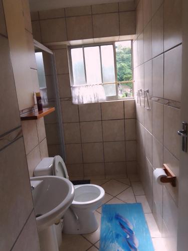 a bathroom with a toilet and a sink at Beach Retreat in Amanzimtoti