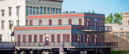 a building with a balcony on the side of a river at Main Street Inn in Lowell