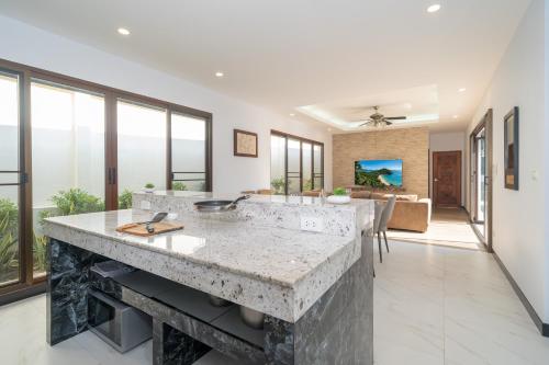 an open kitchen with a large marble counter top and large windows at 3BR Pool Green Park Villa near Rawai Beach in Ban Saiyuan (1)
