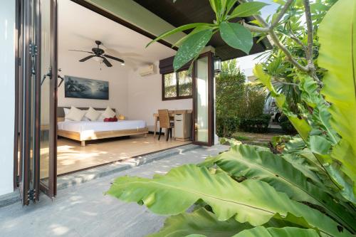 a bedroom in a villa with a bed and some plants at 3BR Pool Green Park Villa near Rawai Beach in Ban Saiyuan (1)