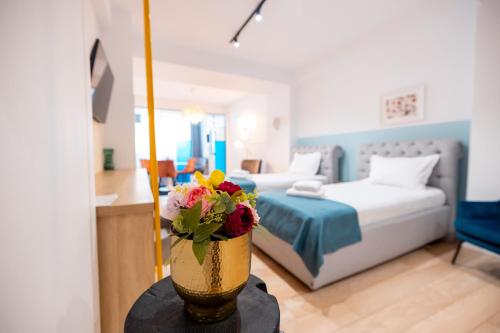 a bedroom with a bed and a vase with flowers on a table at Stil Old Town Boutique Hotel in Bucharest