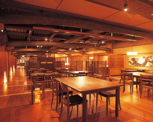 a dining room with wooden tables and chairs at Hotel Kinparo in Toyooka