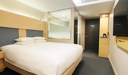 a bedroom with a large white bed and a window at Hotel Midcity Myeongdong in Seoul