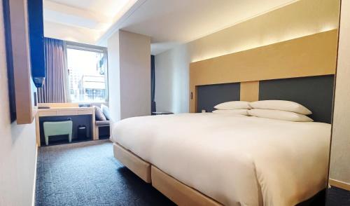 a hotel room with a large bed with pillows at Hotel Midcity Myeongdong in Seoul