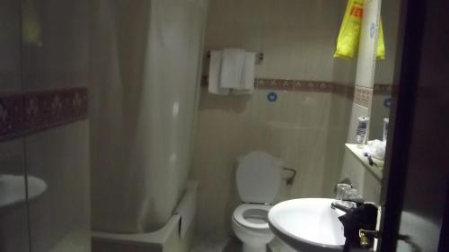 y baño con aseo blanco y lavamanos. en Hostal Rivera - Atocha en Madrid