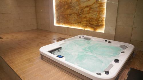 a jacuzzi bathtub with blue water in a bathroom at فندق البرج الابيض - White Tower Hotel in Ōlmush