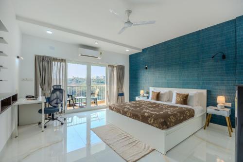 a bedroom with a bed and a blue wall at ALAYA STAYS Midpoint UMA Pet-Friendly 7 BHK Villa Pool and Entertainment in Chicalim