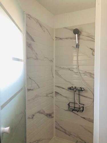 a bathroom with a shower with marble walls at L A P tite Médocaine in Lesparre-Médoc