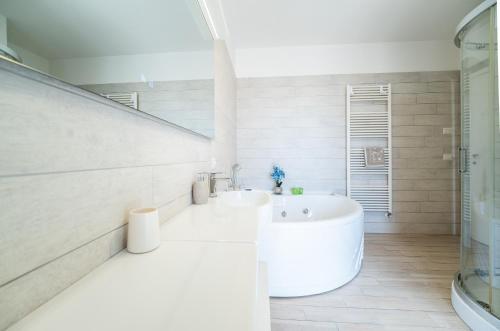 a white bathroom with a tub and a sink at Avola Sun & Sea Sicily in Avola