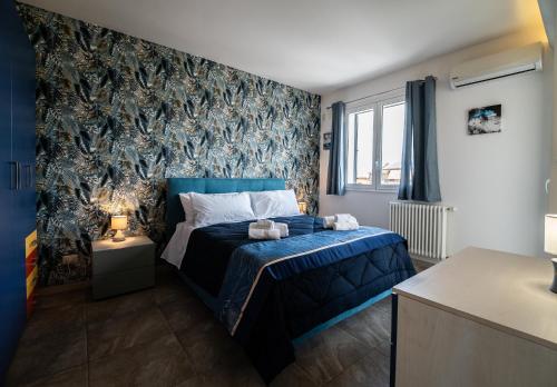 a bedroom with a blue bed and a wall at Avola Sun & Sea Sicily in Avola