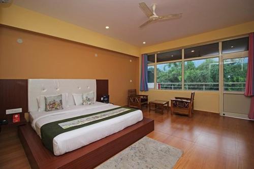 a bedroom with a large bed with a ceiling fan at Red carpet hotel in Kangra