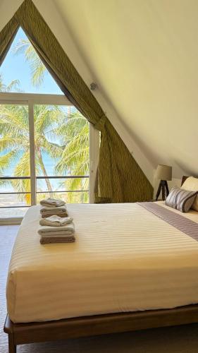 a bedroom with a large bed with a large window at Beachfront Pool Villa in Ko Chang