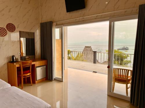a bedroom with a bed and a view of the ocean at Prasi Sunrise Sea View in Nusa Penida