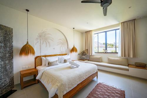 a bedroom with a large bed and a large window at Casa Capucine Uluwatu in Uluwatu