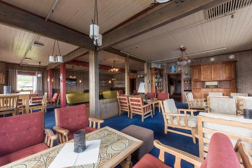 um restaurante com mesas e cadeiras de madeira e mesa em Bergsjøstølen Fjellstue em Bergsjostolen