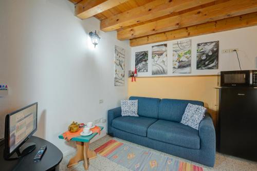 a living room with a blue couch and a table at Vida Boa Apartments in Nago-Torbole