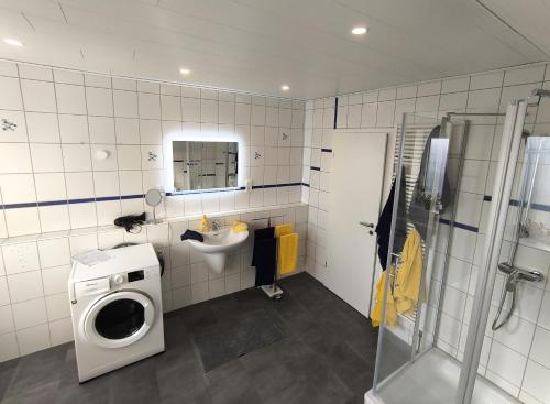 a bathroom with a washing machine and a sink at Zum Schlafwandler in Mengerschied