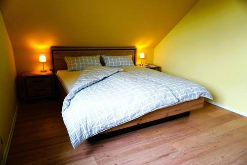 a bedroom with a bed with two night stands and two lamps at Zum Schlafwandler in Mengerschied