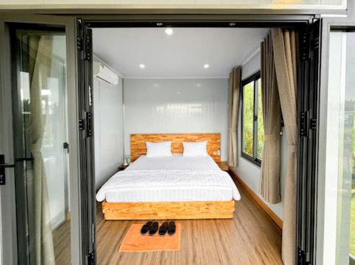 a bedroom with a bed and a large window at ANORA Homestay in Vũng Liêm