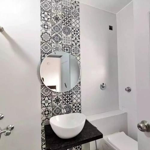 a bathroom with a sink and a mirror on a wall at MARIGOLD VILLA Il 3BHK II AC II POOL II in Lonavala