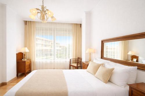 a bedroom with a large white bed with a window at Holibai Amieiro Apto amplio y luminoso cerca de la playa, Baiona in Baiona