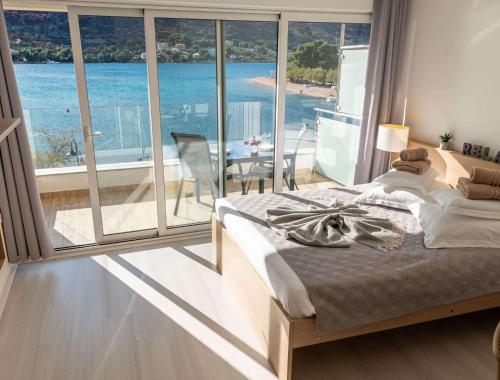 a bedroom with a bed and a view of the ocean at Holidays Roko - Sea View Apartments with Pool in Grebaštica