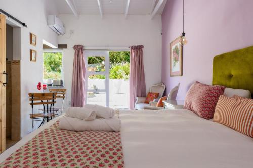 a bedroom with a large white bed and a table at The Botanical House in Somerset West