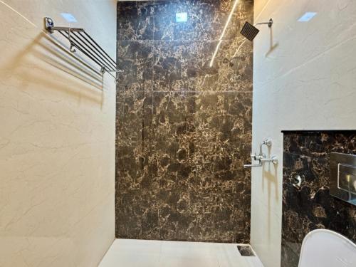a bathroom with a shower with a black wall at SR Palace - Best Hotel in Vrindavan Near Prem Mandir and Iskcon Temple with Private Parking in Vrindāvan