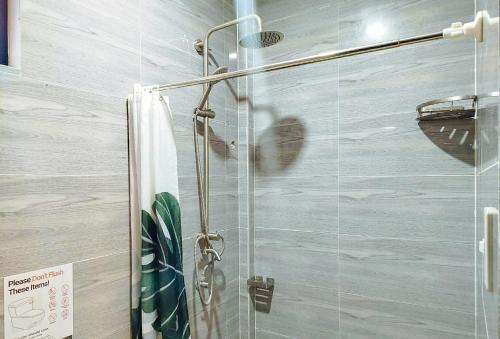 a shower in a bathroom with a glass door at RedDoorz at Balai Malinawon Siargao in General Luna