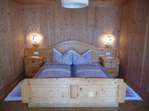 インナーヴィルグラーテンにあるBiohof Jeneweinのベッドルーム1室(木製ベッド1台、ナイトスタンド2台付)