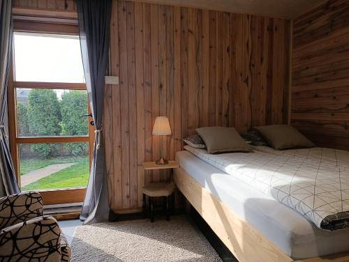 a bedroom with a bed and a large window at TESLA Garden & Spa in Veternik