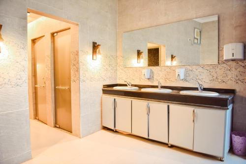 a bathroom with two sinks and a mirror at LALA LAND Fayoum in Tunis