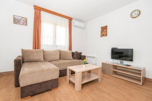 a living room with a couch and a tv at Ethno Village St George in Cetinje