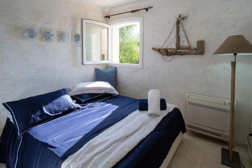 a blue bed in a room with a window at Hotiday Apartment Liscia Di Vacca in Porto Cervo