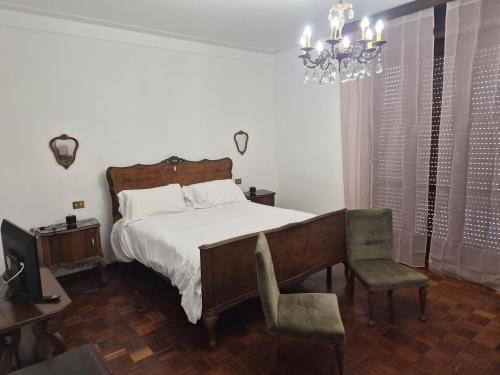 a bedroom with a bed and a chair and a chandelier at Villa Cantalupo 1 in Sillavengo