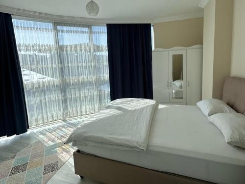 a bedroom with a large bed and a large window at Ada Mevan Otel in Ipekyolu